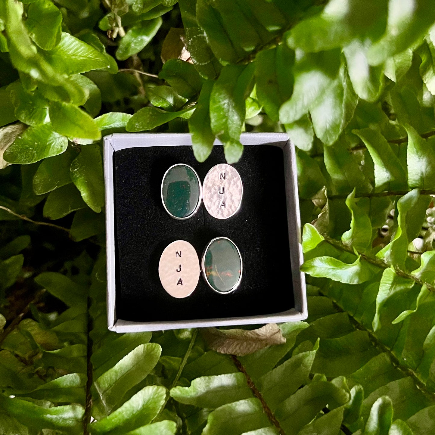 Personalised bloodstone & sterling silver cufflinks on a leafy background.