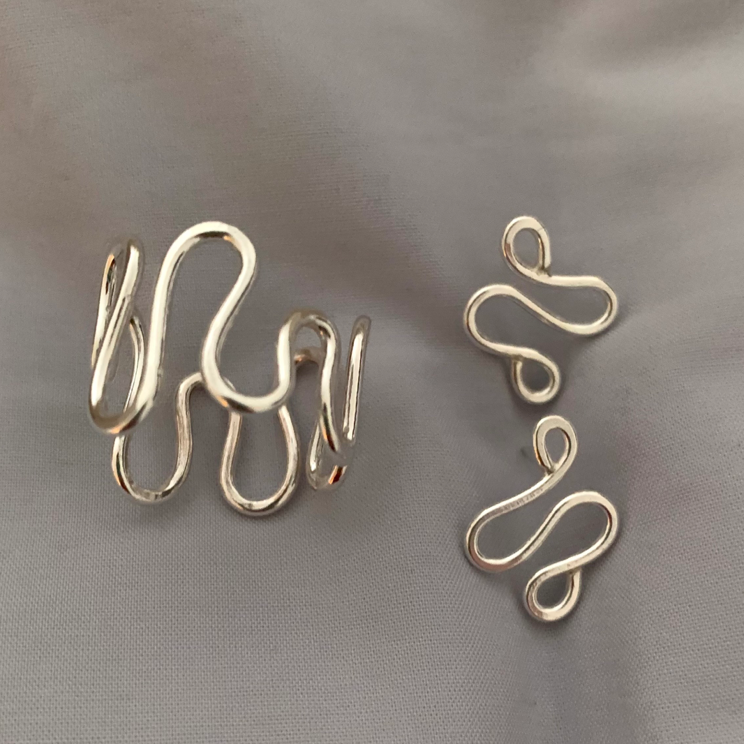 Handmade, sterling silver earrings in a unique ripple shape shown with the matching ripple ring.