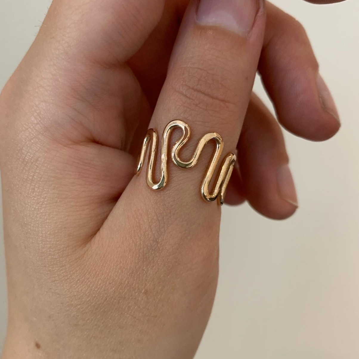 A gold-filled ripple ring on a hand.