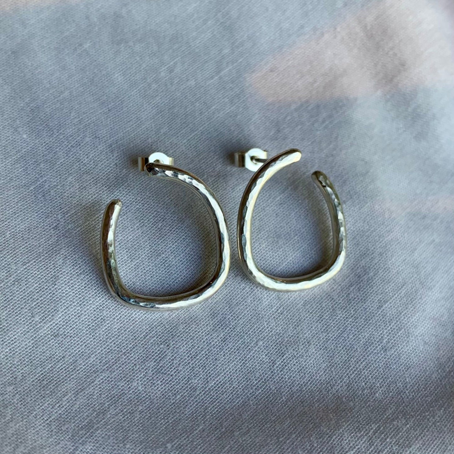 Handmade hammered sterling silver irregular hoop earrings.