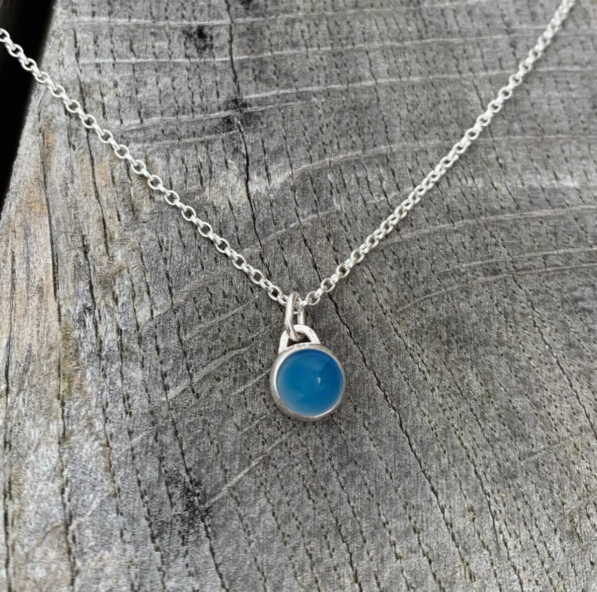 A blue agate stone set in silver on a sterling silver chain.