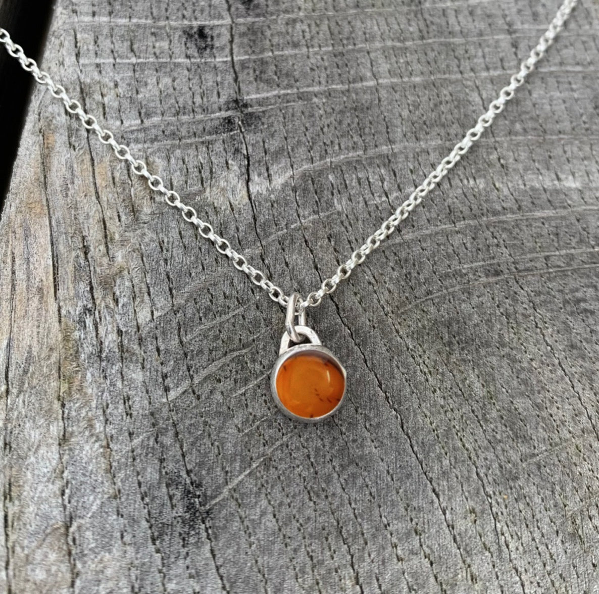 An amber stone set in silver on a sterling silver chain.