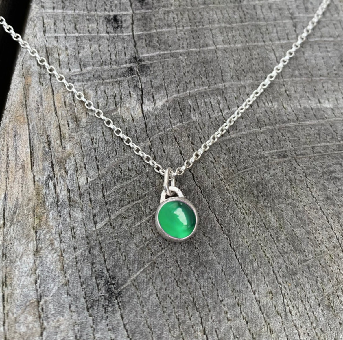 A green onyx stone set in silver on a sterling silver chain.