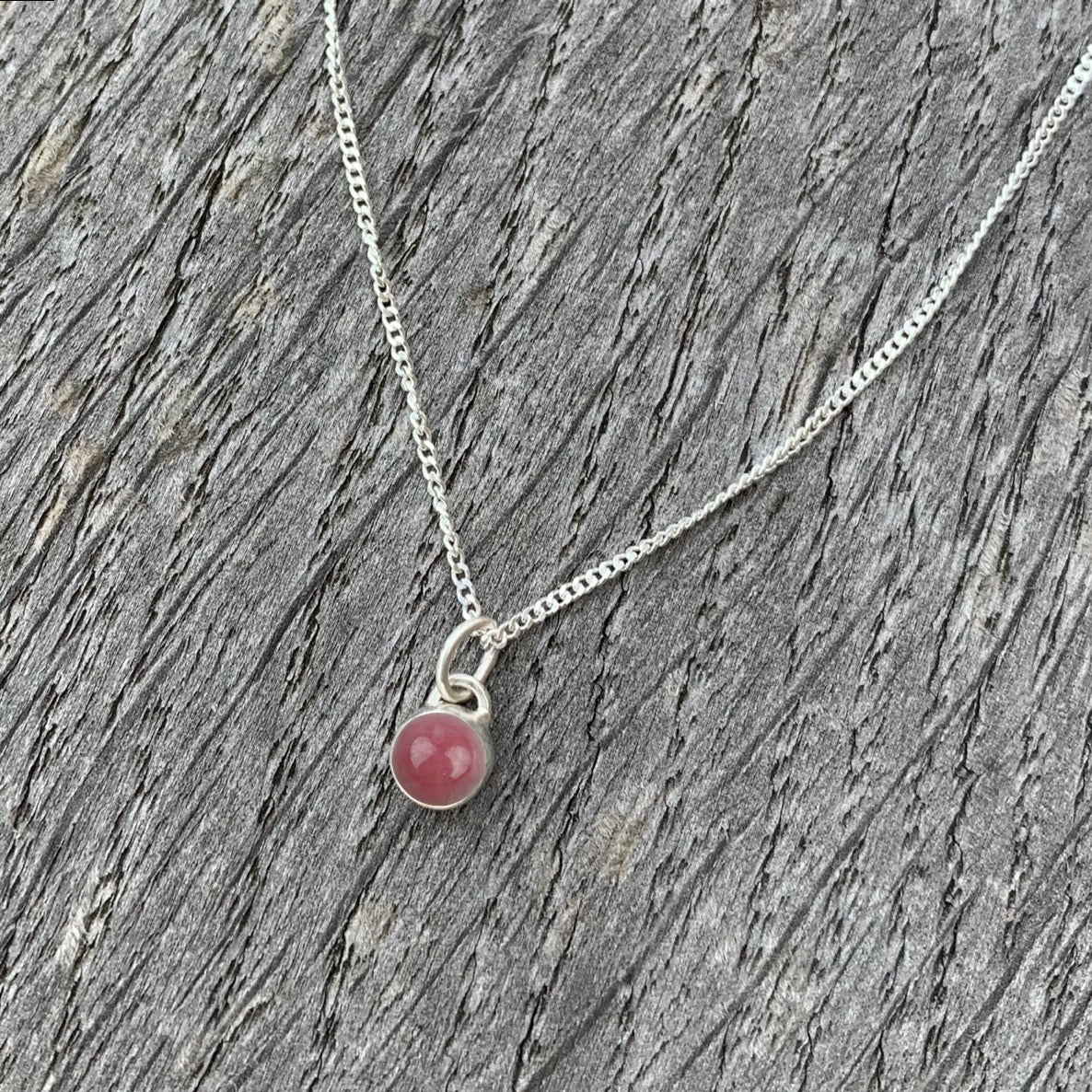 A rhodochrosite stone set in silver on a sterling silver chain.