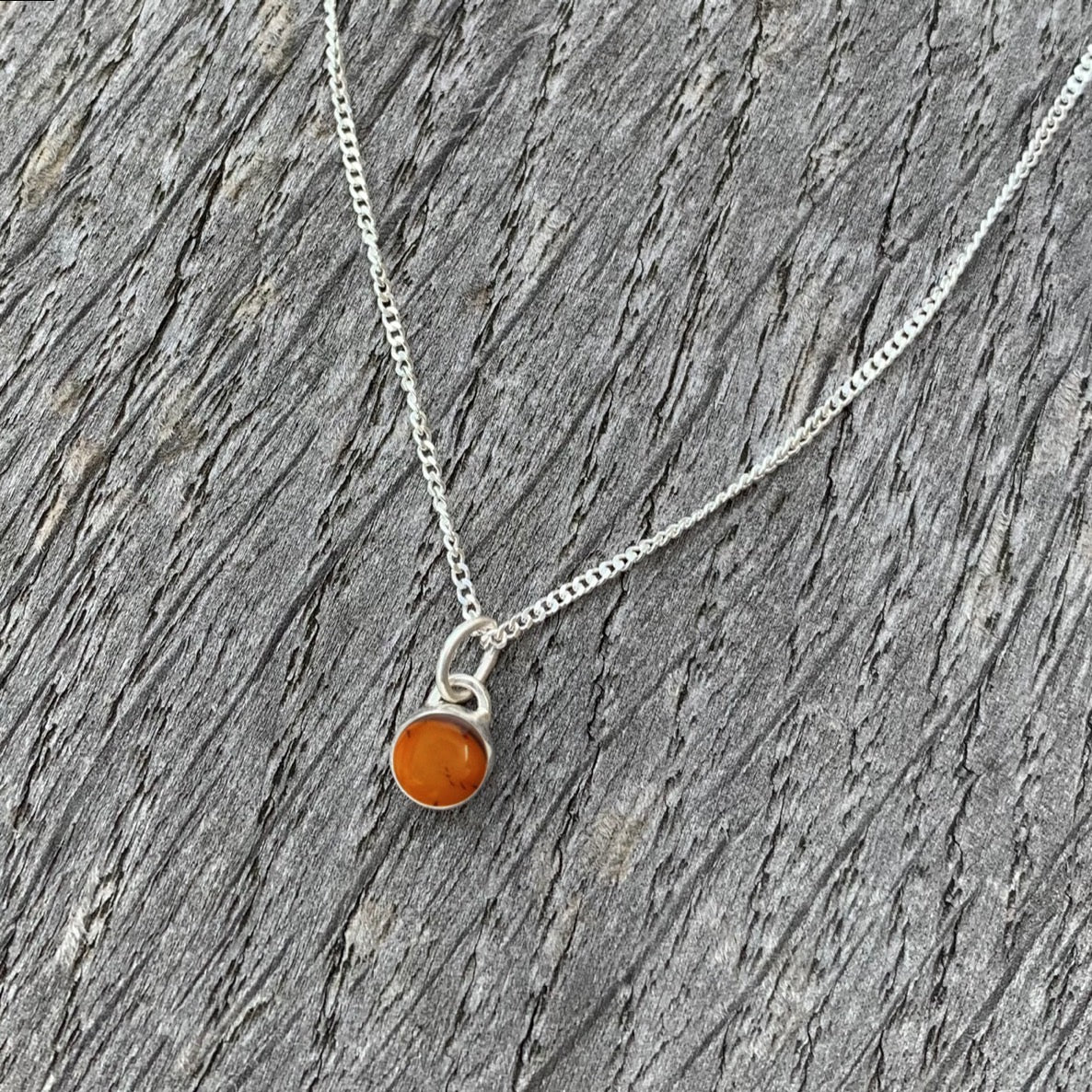 An amber stone set in silver on a sterling silver chain.