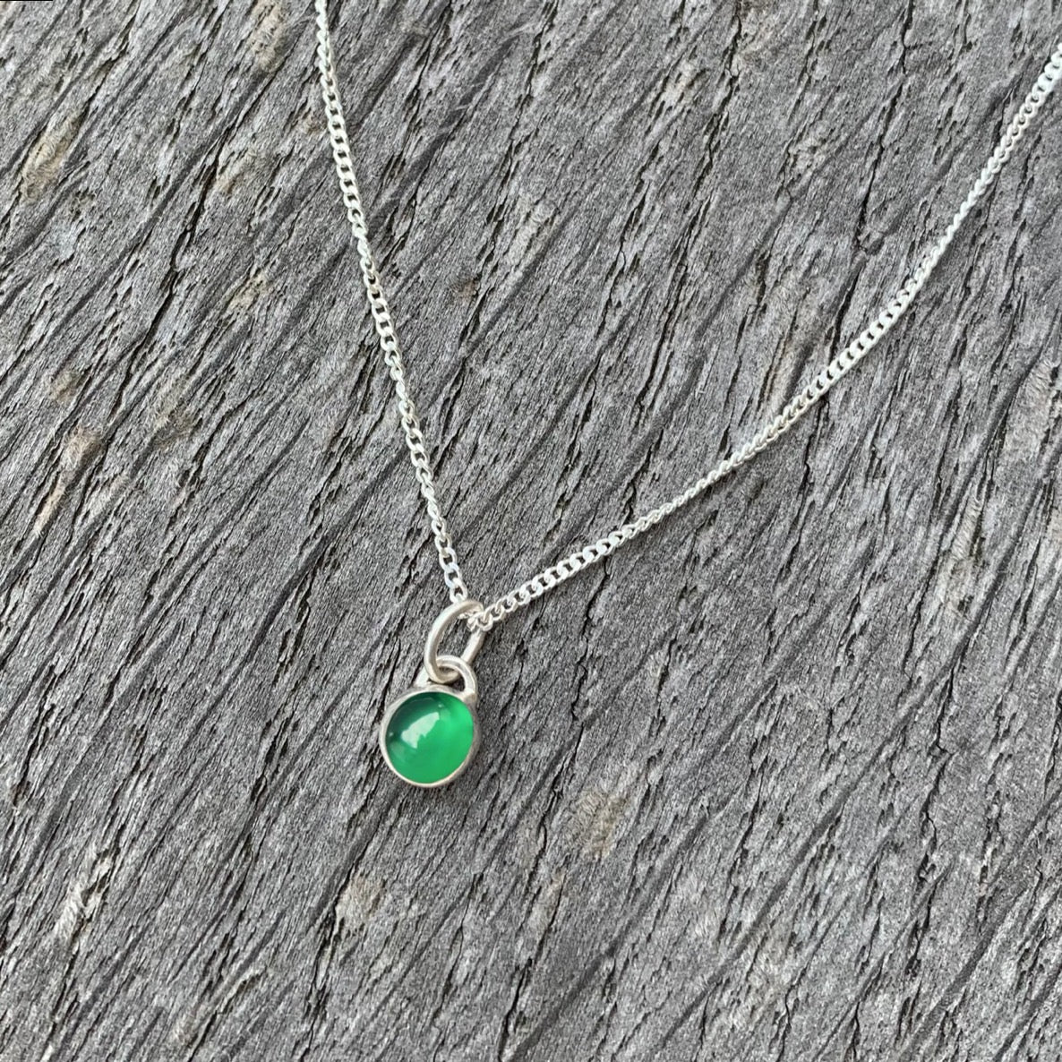 A green onyx stone set in silver on a sterling silver chain.