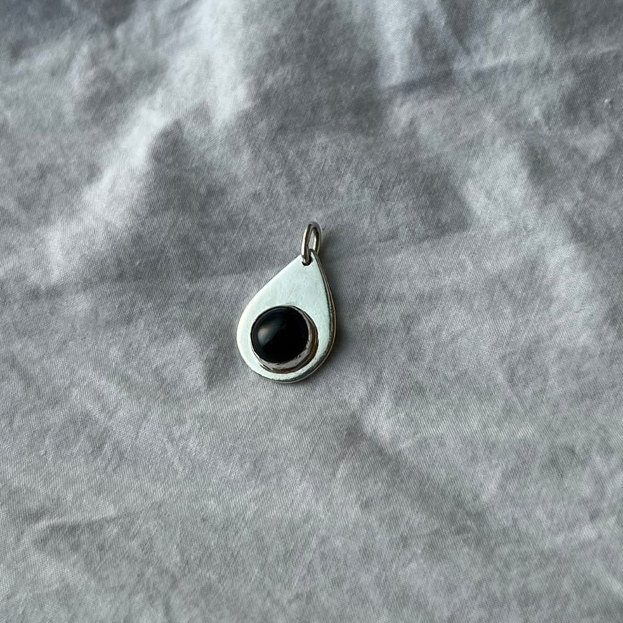 A black onyx stone set on a sterling silver teardrop pendant.