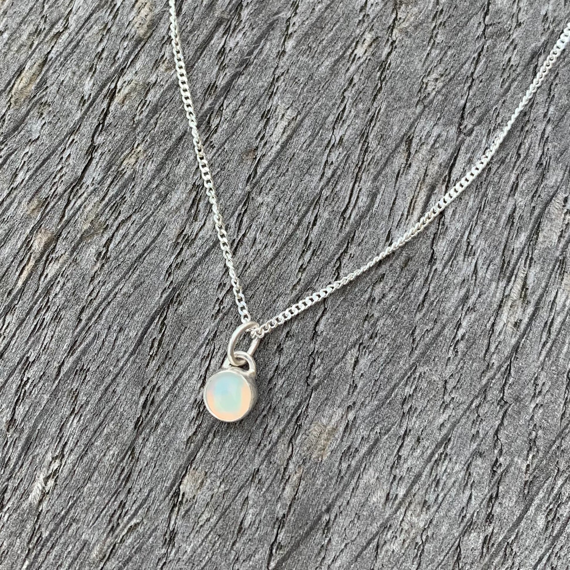 A rainbow opal stone set in silver on a sterling silver chain.