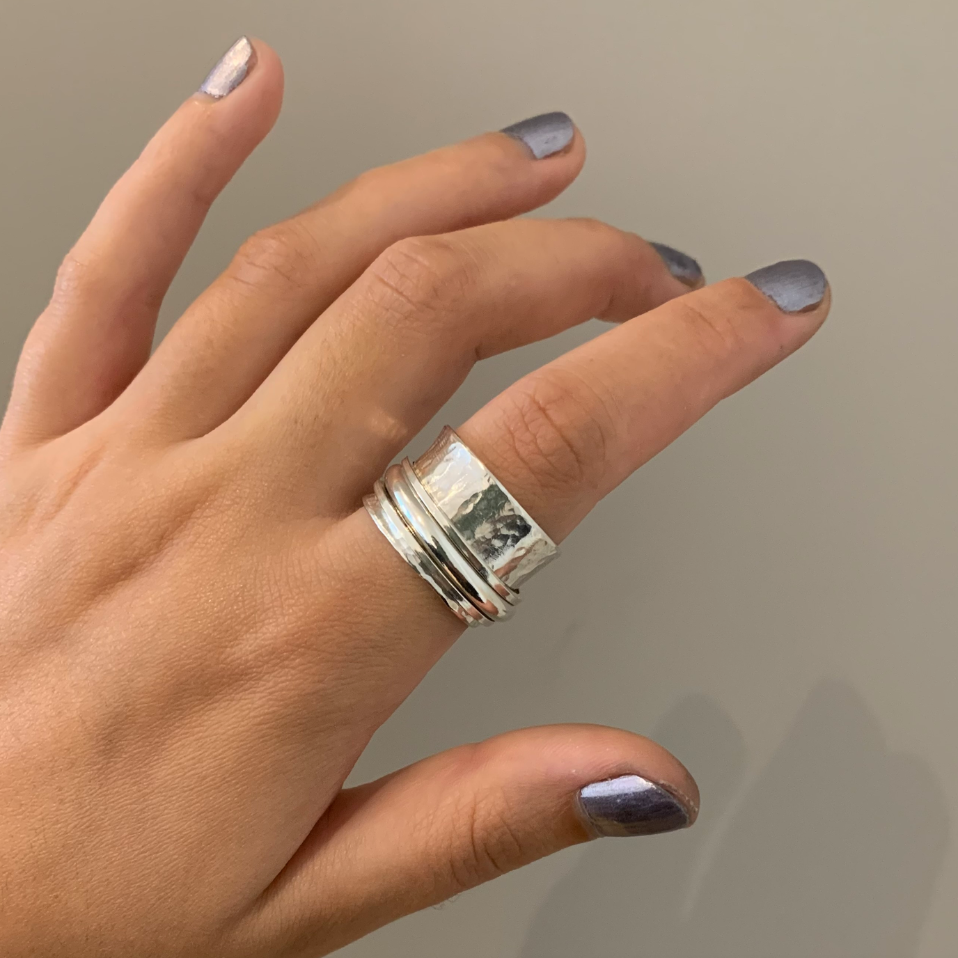 A sterling silver spinner ring with three silver spinning bands.