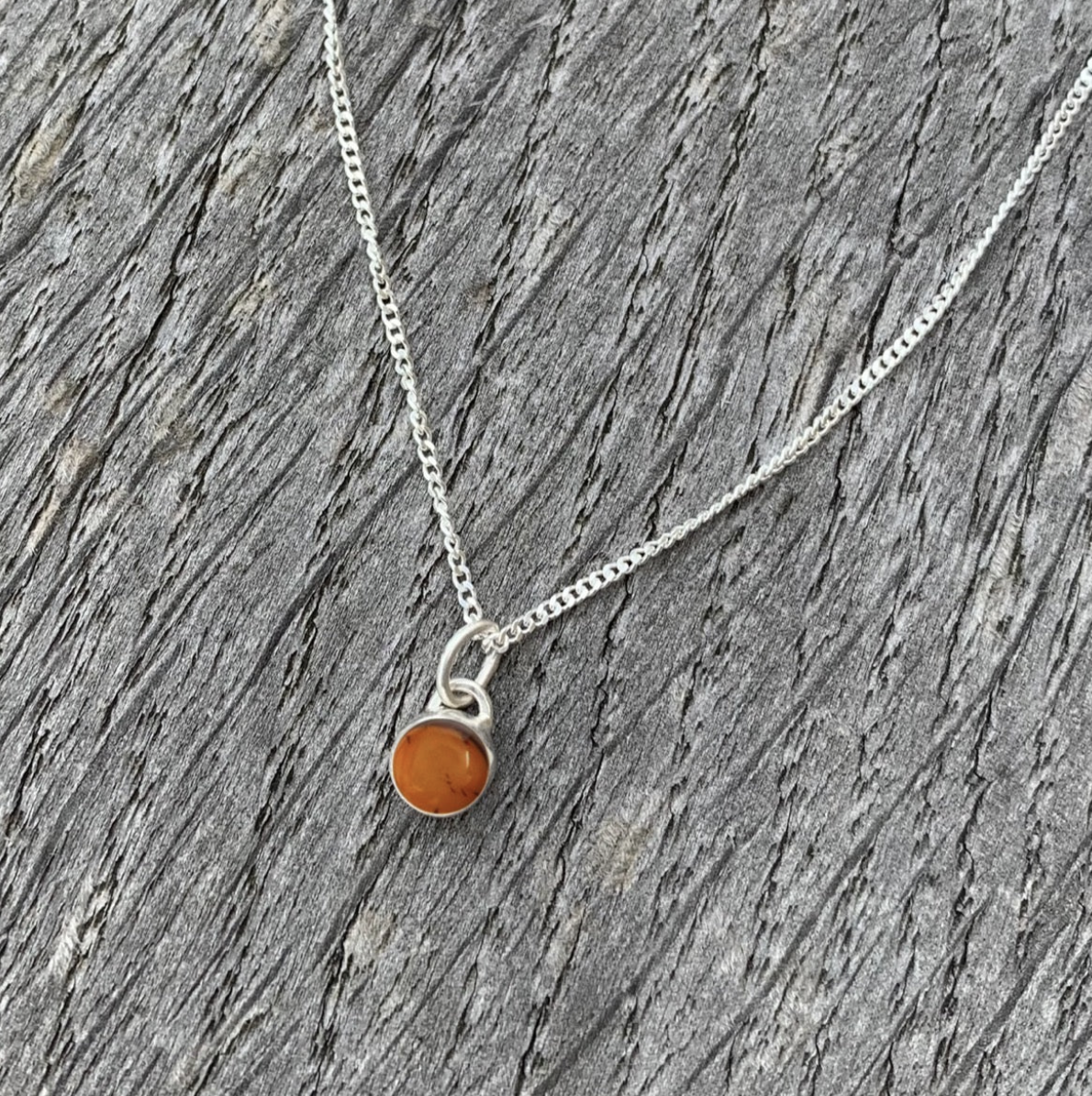 An amber and sterling silver charm necklace.