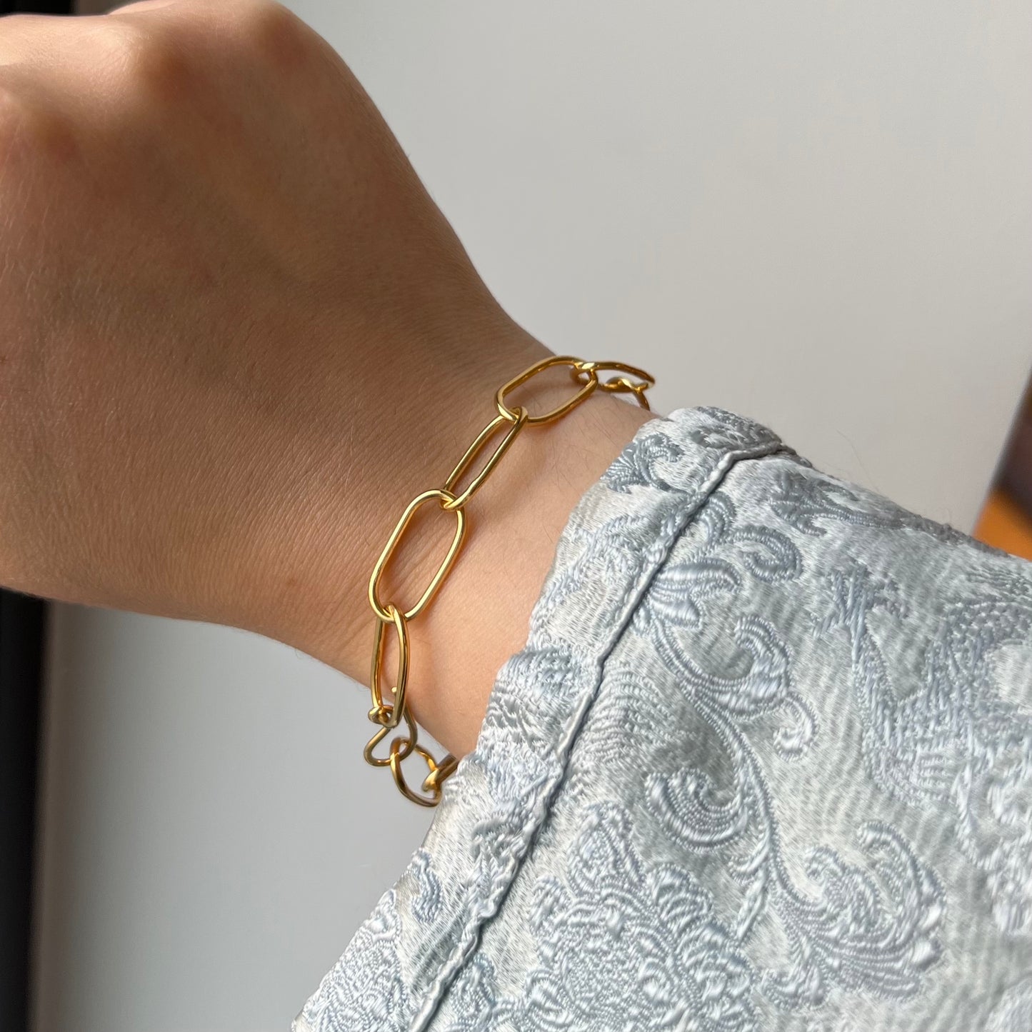 A handmade gold vermeil oval chain link bracelet on a model.